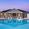 resort style pool with seating with a building behind it